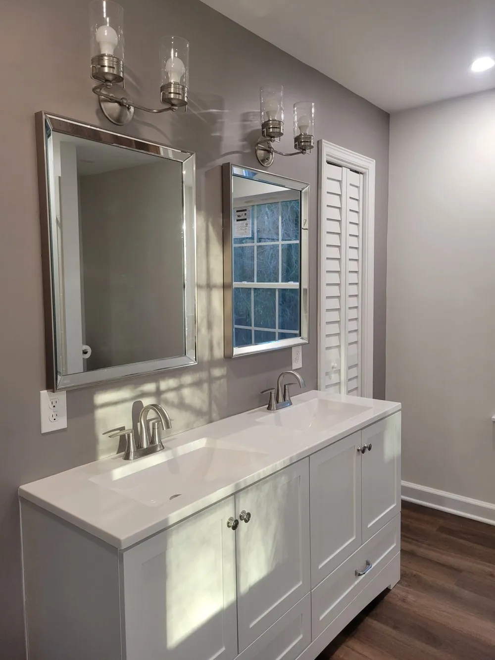 Sunlit bathroom with a double vanity and rectangular beveled mirrors
